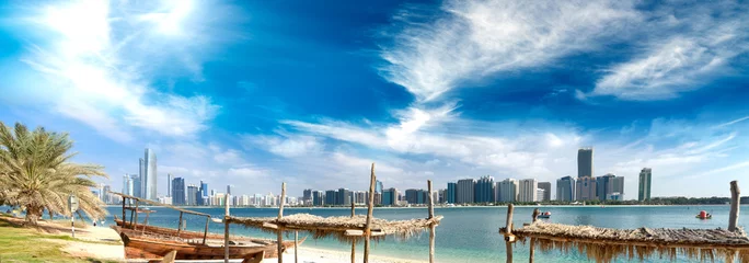 Selbstklebende Fototapete Abu Dhabi Panoramablick auf die Skyline von Abu Dhabi Downtown vom Strand bei Sonnenuntergang, Vereinigte Arabische Emirate