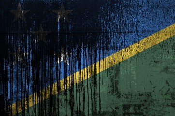 Solomon Islands flag depicted in paint colors on old and dirty oil barrel wall closeup. Textured...