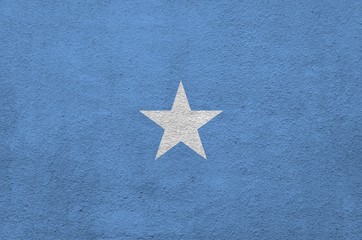 Somalia flag depicted in bright paint colors on old relief plastering wall. Textured banner on...