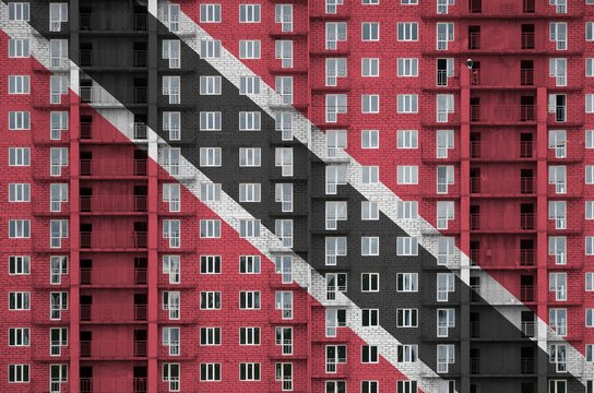 Trinidad And Tobago Flag Depicted In Paint Colors On Multi-storey Residental Building Under Construction. Textured Banner On Brick Wall Background