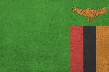 Zambia flag depicted in bright paint colors on old relief plastering wall. Textured banner on rough...