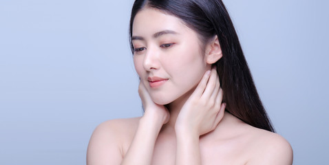 Beauty portrait of a young beautiful woman with hand on her neck shoulder isolated on gray background looking at camera, concept for health , asian beauty model.