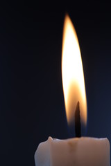 close up burn white candle in the dark