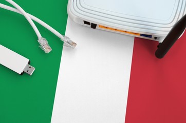 Italy flag depicted on table with internet rj45 cable, wireless usb wifi adapter and router....