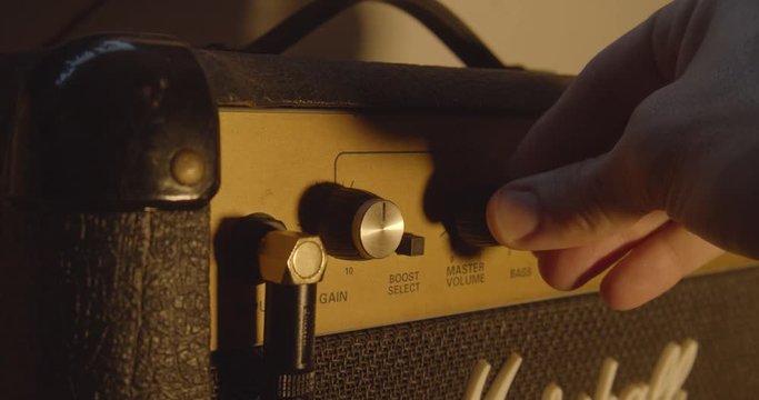 Turning up the volume on a guitar amp.