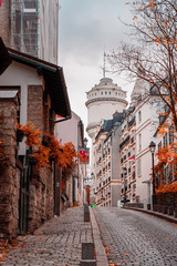 Streets of Montmartre in sunny autumn afternoon, golden trees and cobblestone alley. France. Paris....