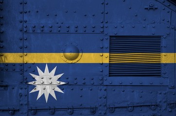 Nauru flag depicted on side part of military armored tank closeup. Army forces conceptual background