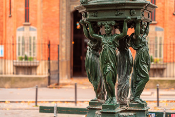 Antique Wallace fountains with drinking water. Women group sculpture. Paris. Autumn.