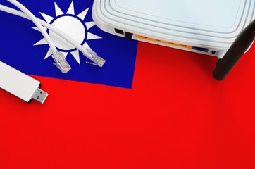Taiwan flag depicted on table with internet rj45 cable, wireless usb wifi adapter and router....