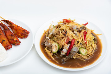 Papaya Salad with Salted Crab and Fermented Fish, served with grilled chicken wings on white background.