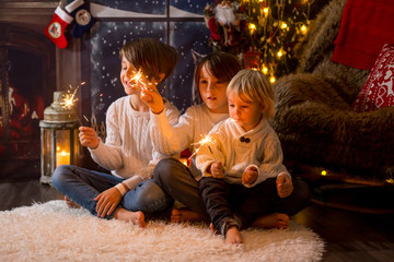 Obraz na płótnie Canvas Preschool children, holding sparkler, celebrating new years eve