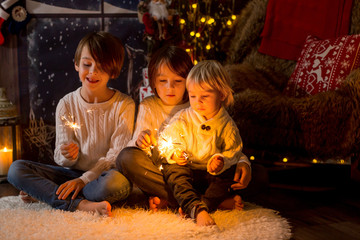 Fototapeta na wymiar Preschool children, holding sparkler, celebrating new years eve