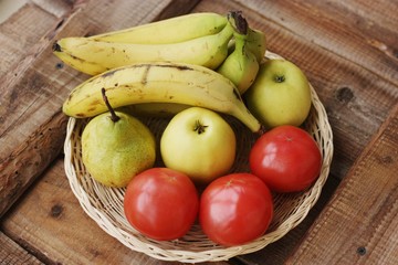 Fruits and vegetables in a wooden basket on the table