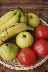 Fruits and vegetables in a wooden basket on the table