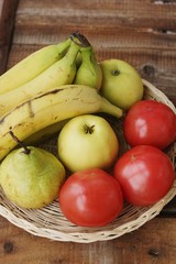 Fruits and vegetables in a wooden basket on the table