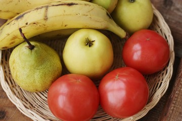 Fruits and vegetables in a wooden basket on the table