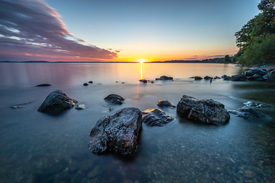 Sonnenuntergang in Chieming in der Langzeitbelichtung mit Steinen im Vordergrund