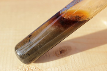 Test tube with small black crystals of iodine in the sunlight.