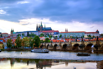 Obraz premium A view of Prague Castle and the Charles Bridge across the Vltava River in Prague, Czech Republic.