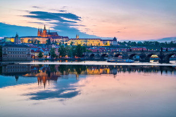 Obraz premium A view of Prague Castle and the Charles Bridge across the Vltava River in Prague, Czech Republic.