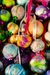 Colourful Christmas baubles. Handmade felted wool, ribbons and jingle bells. Vertical.