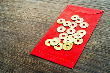 Gold coins on red envelope "Ang pao" on wood background , chinese new year concept.