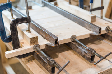 gluing a wooden board. shield from the boards. boards attracted by clamps.