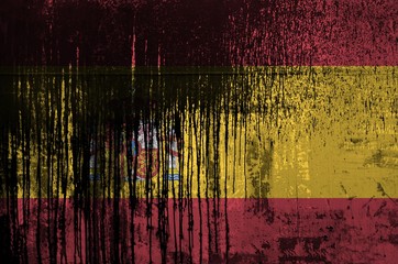 Spain flag depicted in paint colors on old and dirty oil barrel wall closeup. Textured banner on...