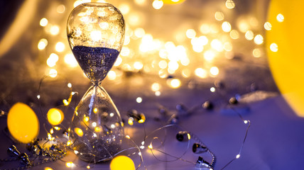 Christmas background, hourglass with silver sand. Vacation approaching concept. Happy New Year