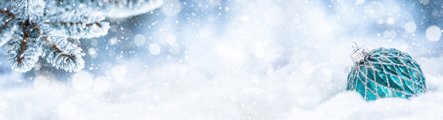 Blue christmas ball on snow with fir branches. Merry Xmas concept - panoramic banner