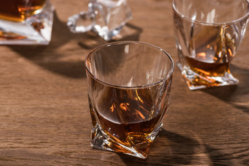 Selective focus of brandy in glasses on wooden table