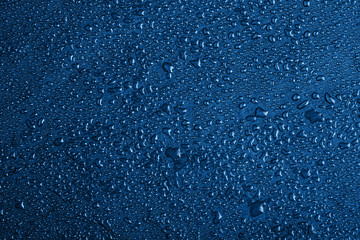 classic blue slate background with water drops or natural stone texture. Black board for serving close-up. Color of the year 2020. Colorful concept. Top view