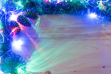Christmas background. Garland glow on a wooden background. Colored christmas lights background