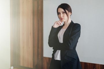 Young attractive emotional girl in business-style clothes on a plain white background in an office or audience