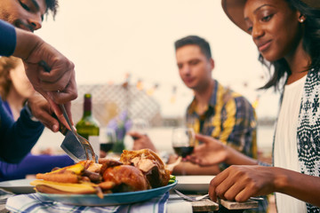 Group of diverse friends having dinner al fresco in urban settin