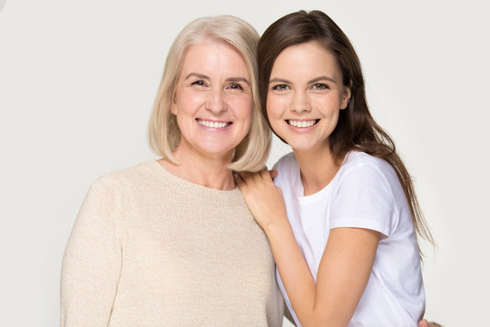 Happy smiling elder mother and millennial daughter posing for portrait
