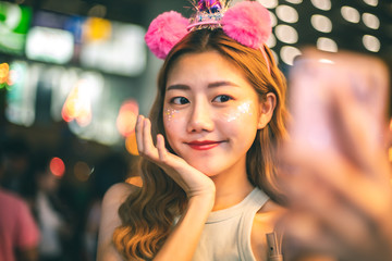 Traveler Asian blogger women travel in Bangkok, Thailand, beautiful female using .Beautiful smiling tourist young  woman having fun at amusement park at hot summer day trip.