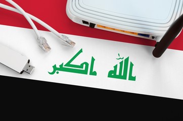 Iraq flag depicted on table with internet rj45 cable, wireless usb wifi adapter and router....