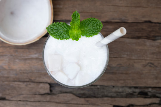 Coconut smoothies white fruit juice milkshake blend beverage healthy high protein the taste yummy In glass drink episode morning on a wooden background from top view.