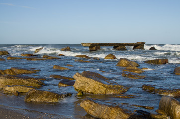 beach landscape with broken pier and stones