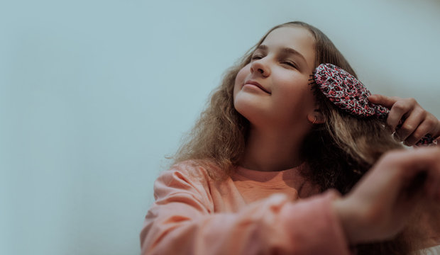 Little girl combing her hair
