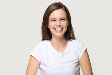 Headshot of young pretty brunette girl sincerely laughing at joke