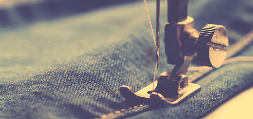 Fototapeta na wymiar Vintage image of sewing machine, macro needle, old jeans