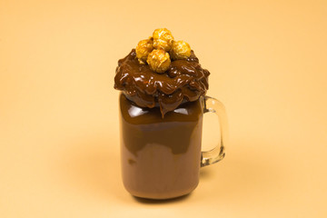 Chocolate milkshake with whipped cream, cookies, waffles, served in glass mason jar. 