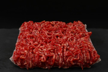 Chopped raw meat  on a black  background.