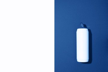 White plastic bottle of cleaning product, household chemicals or liquid laundry detergent on classic blue background. Top view. Flat lay. Copy space. Detergent bottle