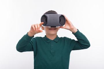 Portrait of happy young boy using VR glasses