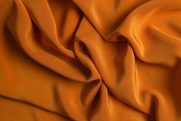 Golden silk or satin luxury fabric texture can use as abstract background.