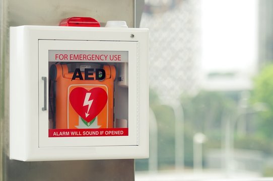 General view of a life saving defibrillator. Portable automated external defibrillator (AED) mounted on the wall in public restroom at airport.