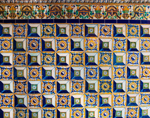 Ceramic mosaic pattern.Colorful floral background. Ceramic mosaic close up. Andalusian ceramic wall. Dirty floral wall fragment photo. Contrast. Tile